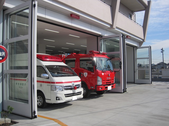 Two doors consist a set of super large folding door. The opening allows a fire fighter truck and two ambulances to drive through.