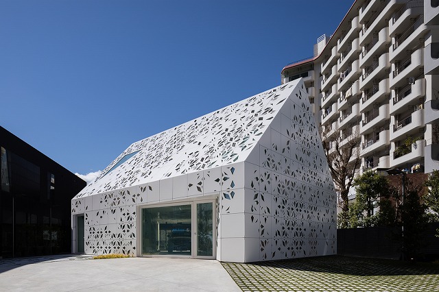 Panels with varying perforation designs cover the exterior of EQ House