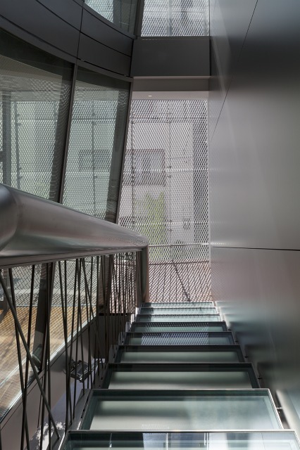 Looking down the stairs from the landing. The glass stair-boards and the see-through balustrades create a transparent space