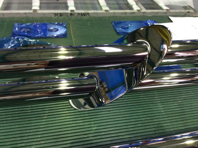 Mirror polished stainless steel oval disk and round pipe, before the coloured clear coating