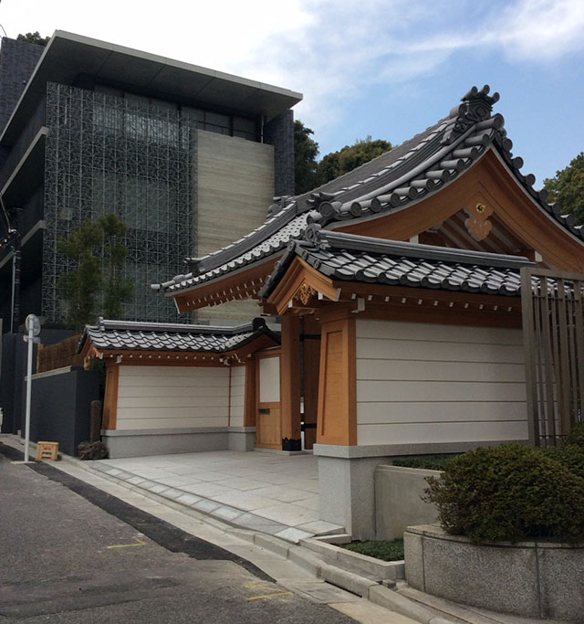 The temple wall and the living quarters. The left building is covered in the aluminium relief wall fabricated from casting