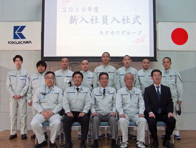 前列には当社役員、後列には新入社員とベトナム技能実習生が並ぶ記念写真