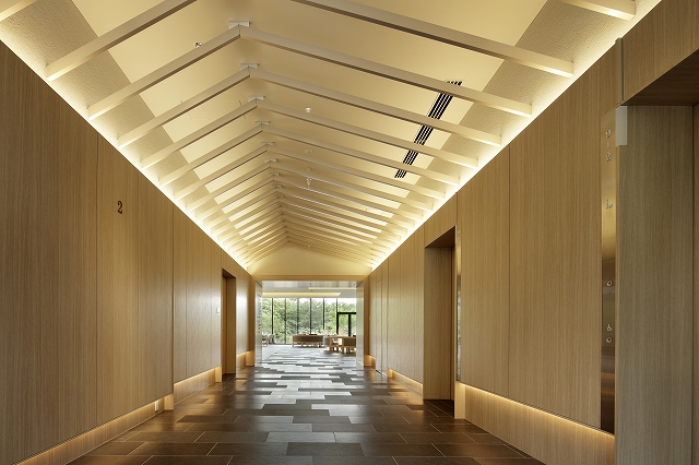 偏芯した山型アルミルーバー天井の2Fエレベーターホール